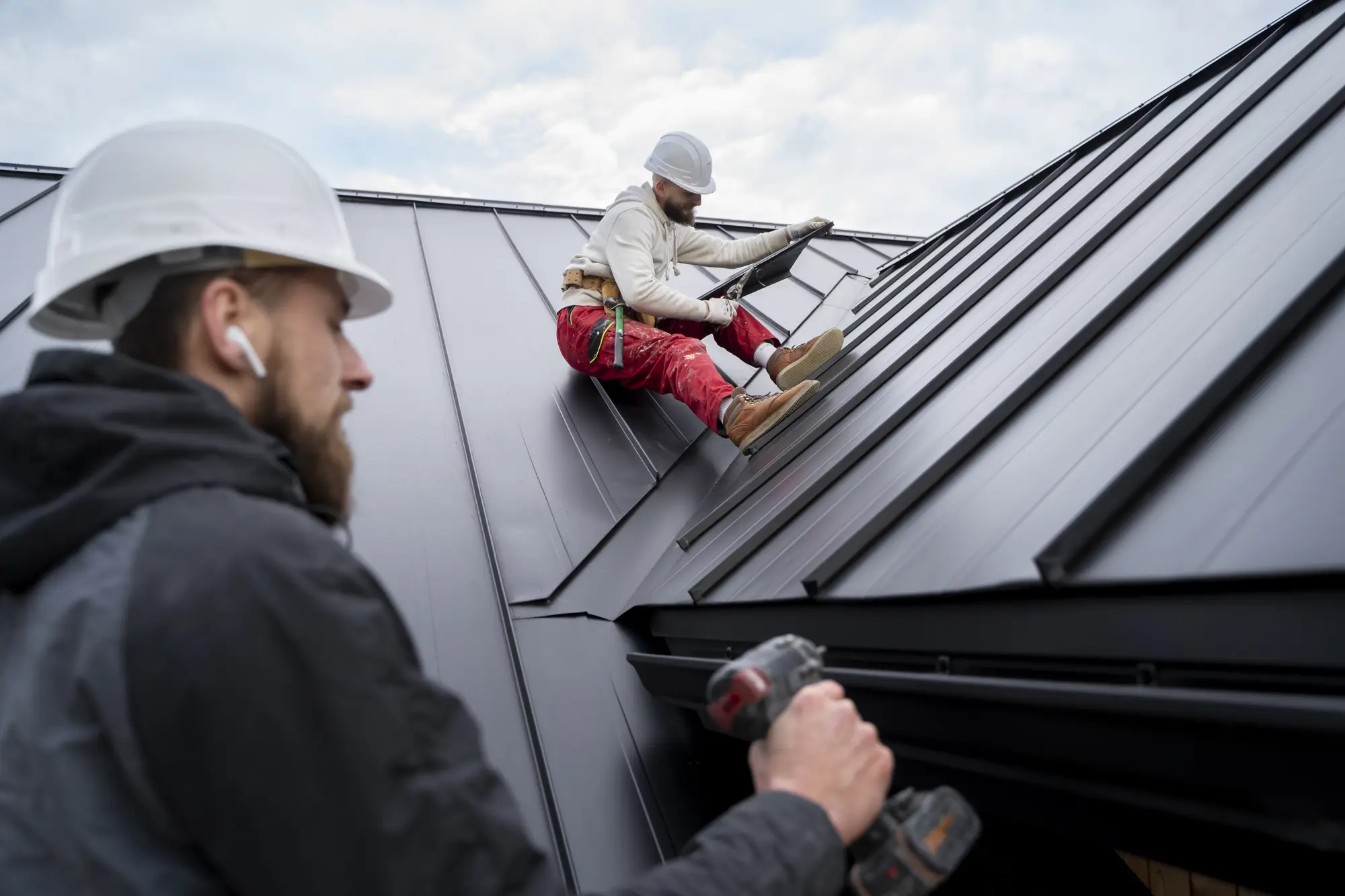 Roofing crew installing a metal roof